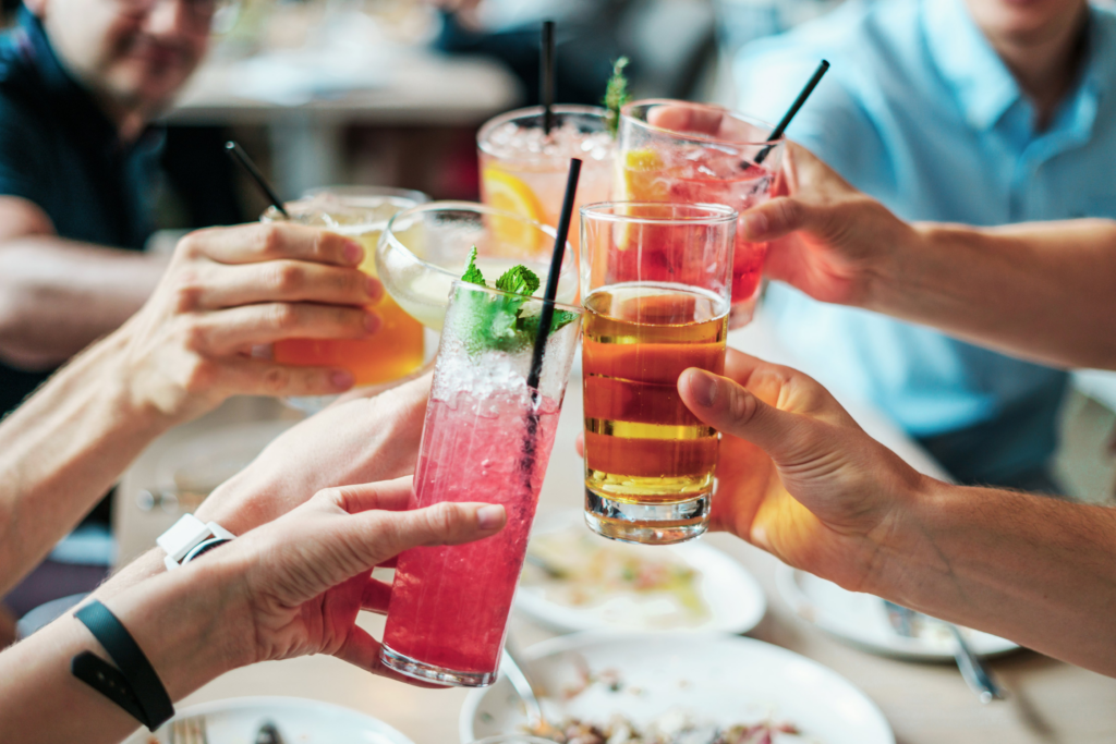 Group of hands with alcoholic drinks doing cheers