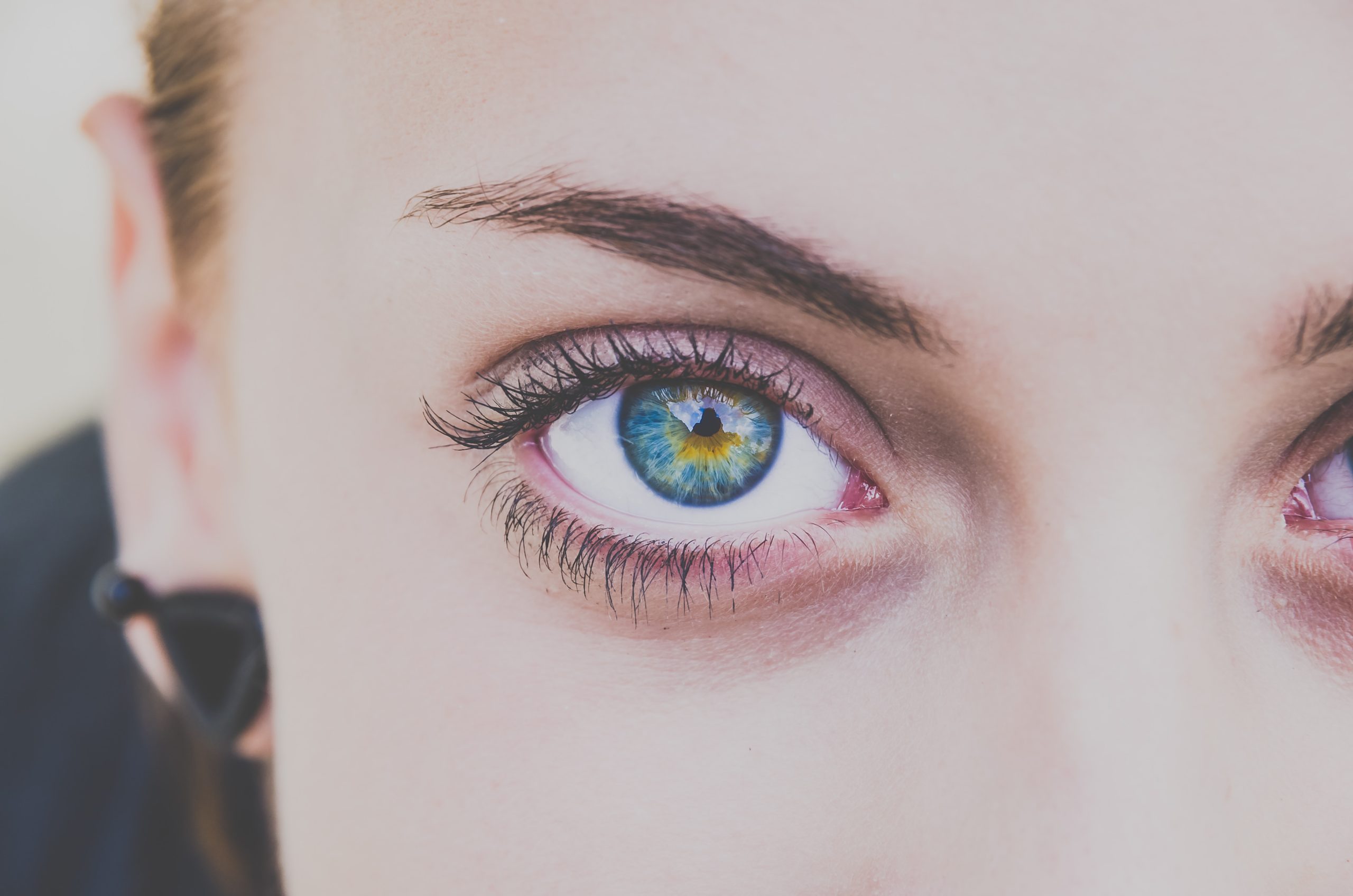 close up photo of womens blue right eye